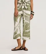 Pantalón tipo pantacourt confeccionado en viscosa con estampado de follaje verde sobre fondo blanco, con cintura elástica y diseño de pierna ancha y corta.