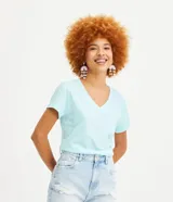 Blusa blanca de algodón con cuello en V, manga corta y bolsillo frontal.