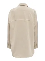 Camisa oversize color beige de pana con cuello clásico, cierre frontal con botones, mangas largas con puños abotonados, dos bolsillos con botón en el pecho y ruedo asimétrico.