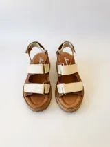 Sandalias de cuero color marrón con plataforma y dos tiras anchas de cuero crudo con velcro.