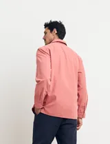 Sobrecamisa verde de manga larga con cuello camisero, cierre frontal con botones y bolsillo de parche en el pecho.