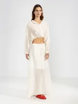 Blusa corta celeste de tejido arrugado liviano, con cuello mao, botones al frente, mangas abullonadas y ruedo elastizado.