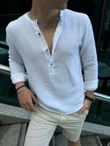Camisa blanca de muselina con cuello mao y abotonadura parcial.