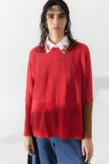 Buzo de punto calado color rojo con cuello camisero blanco y mangas largas color marrón.