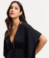 Salida de playa negra, amplia, con abertura delantera, lazo y mangas cortas amplias.