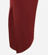 Vestido largo negro de microfibra, corte ajustado al cuerpo, con cuello redondo y escote tipo nadador en la espalda. Presenta una abertura lateral alta en la falda.