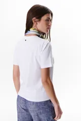 Remera blanca de algodón con cuello redondo y estampado de patrones de costura en el frente.