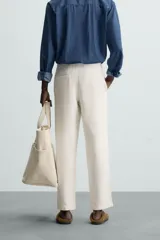 Pantalón verde oscuro de algodón con textura, corte recto, cintura elástica ajustable con cordón, bolsillos laterales y traseros de vivo.