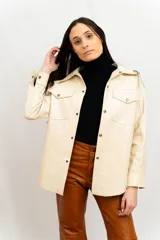 Sobrecamisa de cuero beige, de corte oversized y hombros caídos, con detalles de bolsillos frontales.