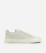 Championes masculinos color crema, con puntera redonda, caña baja, cierre con cordones y suela vulcanizada.
