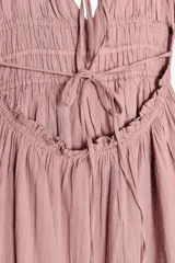 Vestido midi color rosa viejo, confeccionado en algodón. Tiene escote en pico, tirantes finos ajustables y espalda descubierta con tira ajustable.