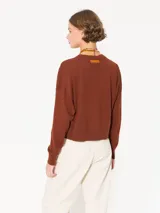 Sweater tejido suave y flojo, color crudo, con cuello redondo y mangas largas.