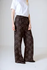 Conjunto de camisa y pantalón marrón con estampado de círculos blancos.