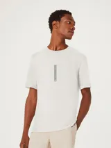 Remera beige de corte recto con estampa vertical en el centro del pecho.