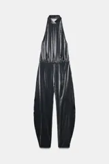 Mono largo negro con cuello halter ajustable con botones a presión, hombros descubiertos, bajo abullonado y cierre en la espalda con cremallera.