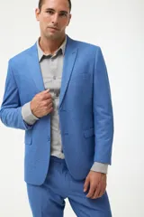 Traje de dos piezas (saco y pantalón) color azul vibrante, con solapa en punta y dos botones. El saco es de corte ajustado.