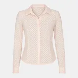 Camisa rosa pálido de tela transparente con textura y pequeños tajos en los costados. Tiene cuello clásico, mangas largas con puños abotonados y cierre frontal con botones.
