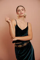 Top verde oscuro de terciopelo con breteles finos y escote en V. Presenta una flor bordada en la espalda.