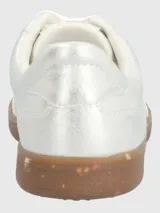 Zapatillas plateadas de cuero sintético con cordones y suela marrón con motas de colores.