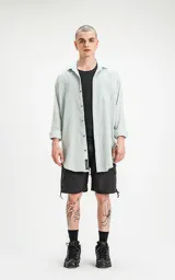 Camisa celeste de manga larga con bolsillo ojal en delantero, cartera escondida y calce oversize.