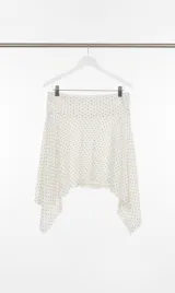 Falda blanca con lunares negros y bajo irregular.
