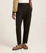 Pantalón zanahoria de poliéster color negro, con cintura elástica en la espalda, pliegues delanteros y abotonado frontal.