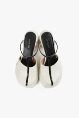 Mule color caramelo con plataforma y taco cilíndrico, tira superior negra y puntera cuadrada.