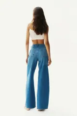 Pantalón de jean azul denim de corte ancho, tiro alto y cinco bolsillos.