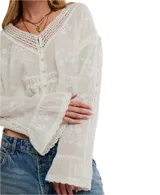 Blusa blanca de manga larga, confeccionada en algodón con bordados florales y detalles de encaje en el escote y mangas. Presenta un escote en V con botones frontales y un cordón ajustable en el bajo para fruncir.