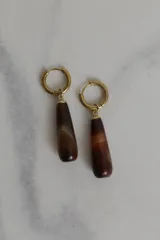 Par de aros colgantes con argolla dorada y dije de piedra natural marrón con vetas blancas.
