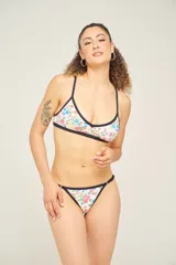 Conjunto de bikini con estampado animal print multicolor, compuesto por un corpiño triangular con tirantes finos y una bombacha tipo colaless con tiras finas ajustables en los laterales.