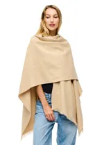 Ruana de tejido soft color beige, con cuello en V y un lazo o pasador frontal para ajustar. El ruedo tiene terminación desflecada.