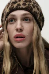 Gorro tipo beanie con estampado animal print en tonos beige y marrón.