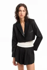Blazer corto negro de manga larga con solapa y bolsillo de pecho en tela brillosa.