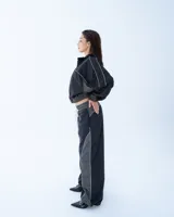 Campera deportiva bomber negra con recortes y vivos blancos.