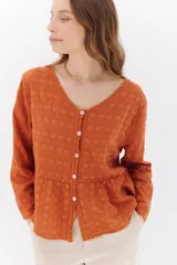 Camisa celeste de algodón con textura arrugada y bordados a tono, escote amplio, mangas largas y botones frontales.