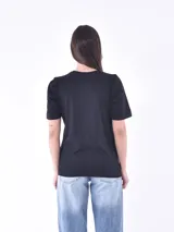 Remera negra de cuello redondo y manga corta con detalle de bordado inglés en las mangas.