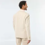 Blazer color beige de lino, corte slim, con solapa de muesca, cierre de dos botones, bolsillo en el pecho y bolsillos delanteros con solapa.