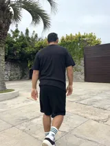 Conjunto negro tejido calado, compuesto por una remera de corte cuadrado y shorts.