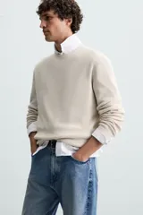 Jersey color crudo tejido en hilatura de algodón, con cuello redondo, manga larga y acabados en rib.