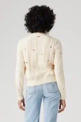 Cárdigan color crema de tejido de punto con diseño de trenzas y bordado de estrellas de colores.