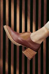 Zapatos de cuero color marrón con puntera fina, detalle de textura en el empeine, diseño slip-on y suela dentada.