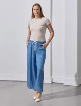 Pantalón capri de lyocell color celeste, corte wide leg, con pretina elástica ajustable con lazo y bolsillos delanteros aplicados.