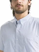 Camisa de hombre de manga corta con estampado a cuadros en tonos blanco, verde y marrón. Tiene cuello abotonado y bolsillo en el pecho.