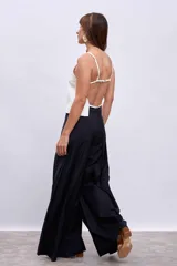 Pantalón palazzo plisado color azul marino, de tiro alto con bolsillos laterales y cierre frontal con botón.