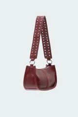 Bolso tipo baguette color borgoña con correa corta para el hombro y tachas plateadas.
