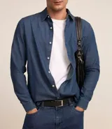 Camisa de hombre de tejido plano de algodón, color celeste claro, con cuello solapa, manga larga y bolsillo simple en el pecho izquierdo.