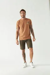 Bermuda de gabardina color beige, corte chino, con bolsillos laterales y traseros, cierre con cremallera y botón, presillas para cinturón y logo bordado.