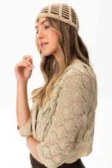 Saco corto color beige tejido a crochet con hilo con lurex y spandex, mangas murciélago y calce amplio.