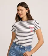 Remera de algodón a rayas horizontales blancas y azules, con cuello redondo y manga corta. Presenta un estampado de cereza con moño en el pecho.